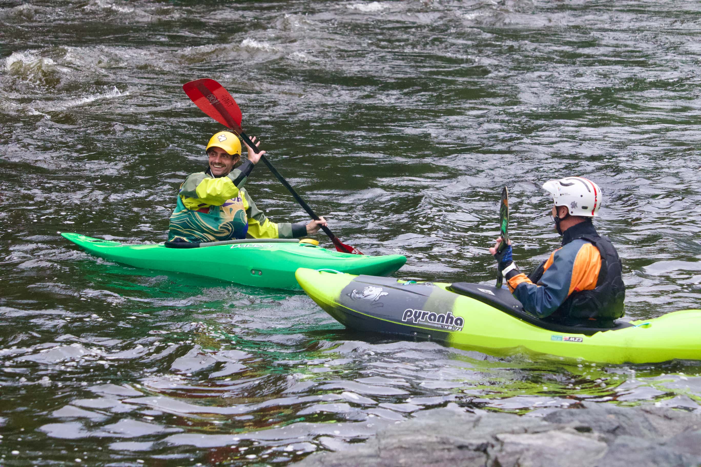 two kayakers paddling in white water