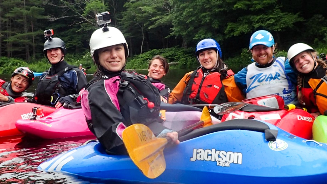 Woman in kayaks with go-pros on their helmets