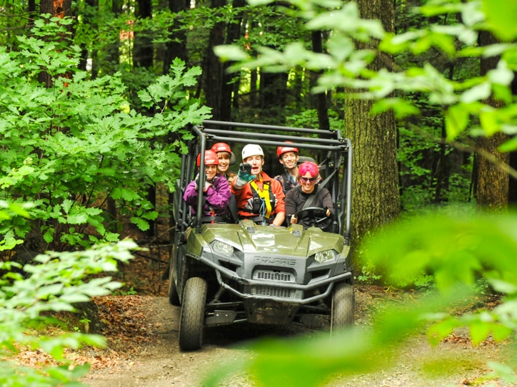 Group of people in an ATV driving through the forest