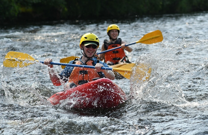 People kayaking through rapids