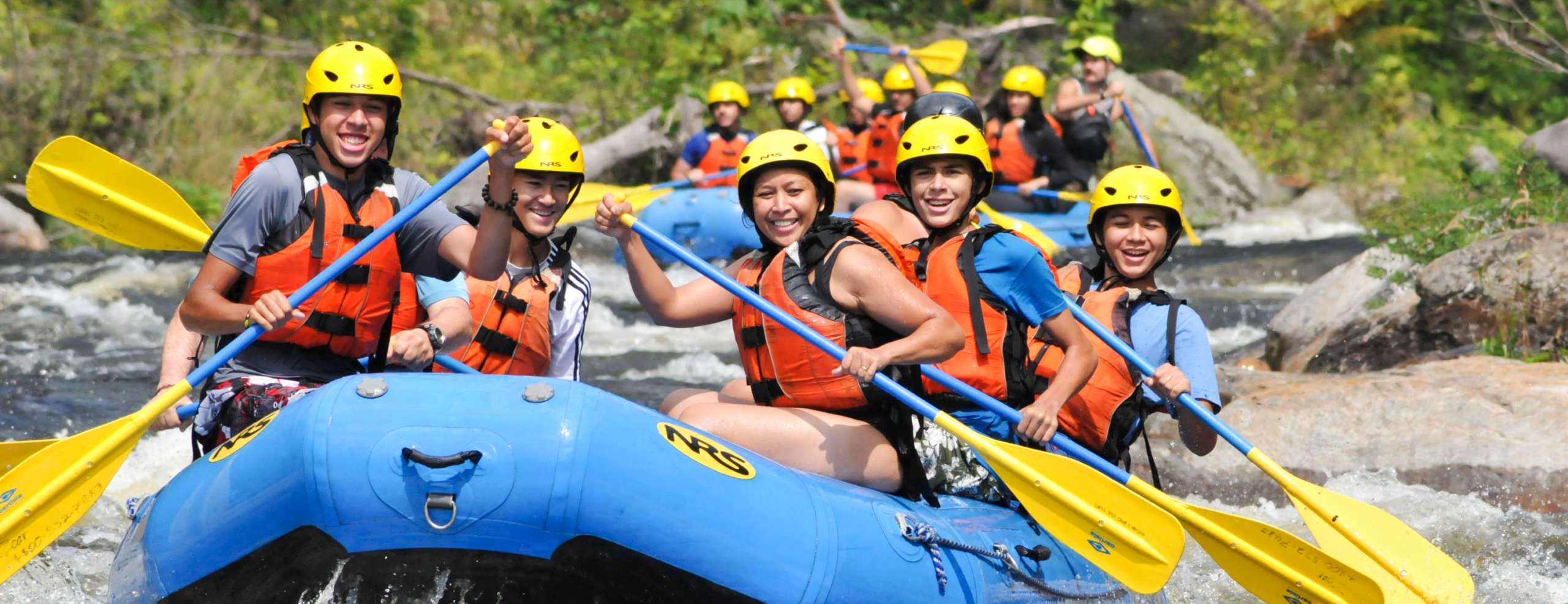 Group of adults rafting down rapids