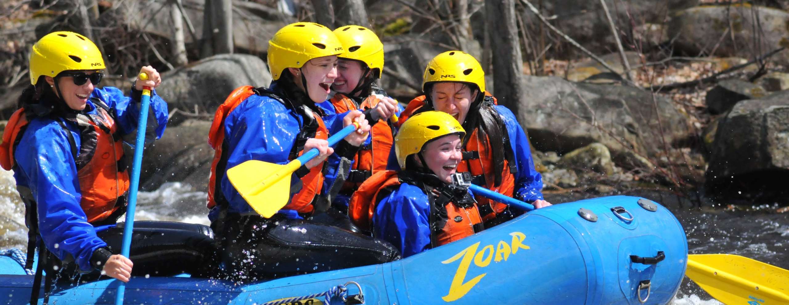 Rafting group having fun and smiling as they navigate rapids