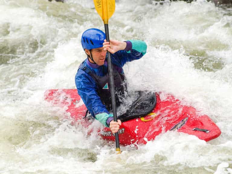 Man kayaking through rough rapids