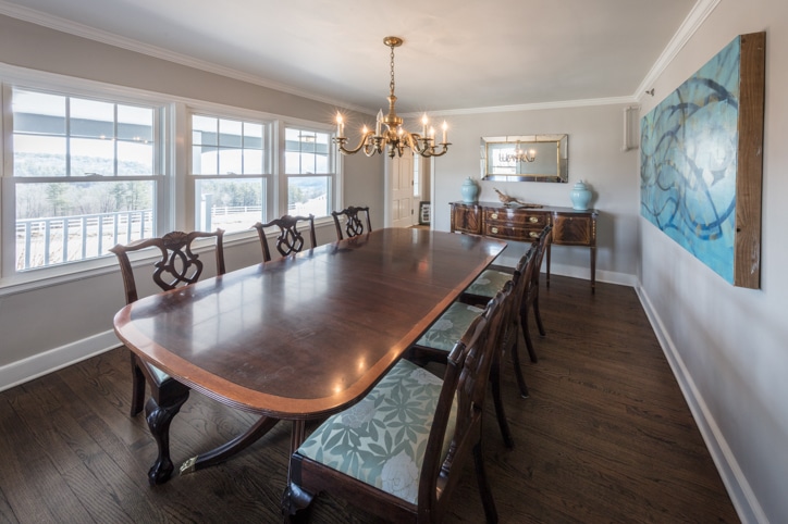 Large wood dining room table and chairs in the bright dining room