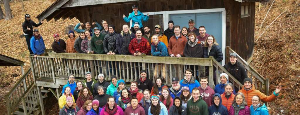 All of Zoar staff gathered outside on a deck for a group photo on a fall day