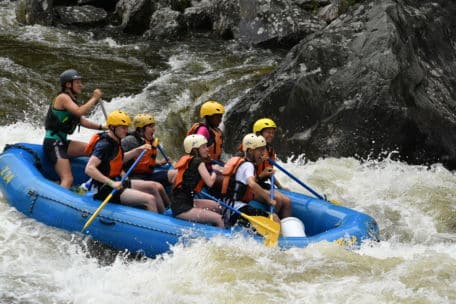 Group of whitewater rafters headed down the rapids at Zoar Outdoor