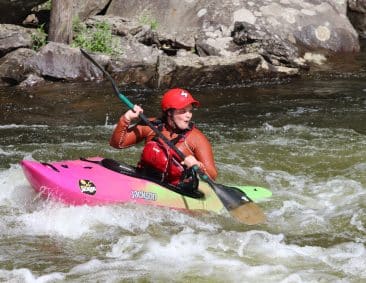woman learning how to kayak on rapids