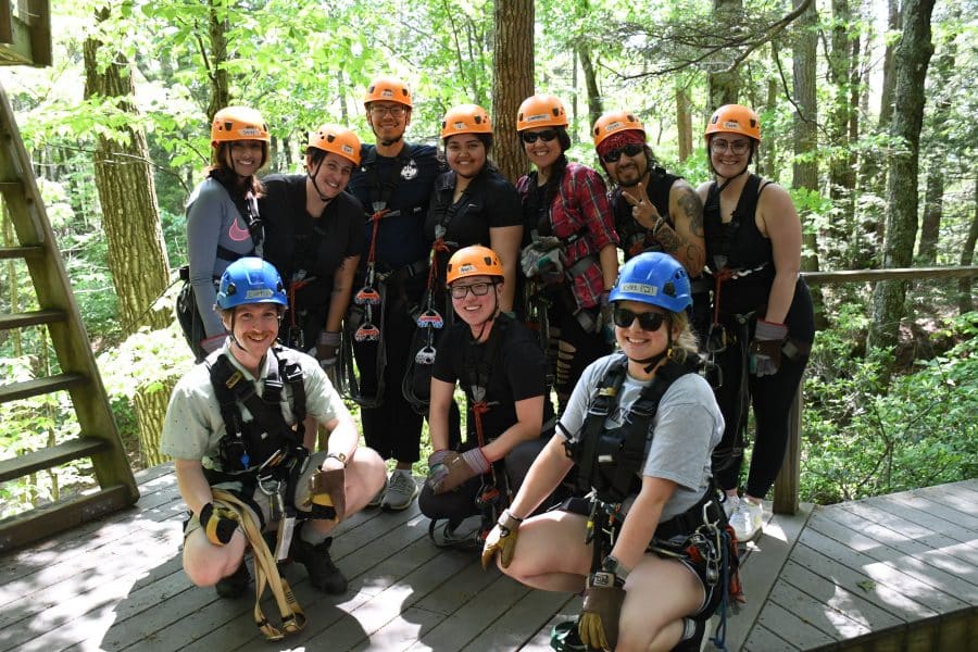 Group of people on a zip lining trip standing on a tree platform