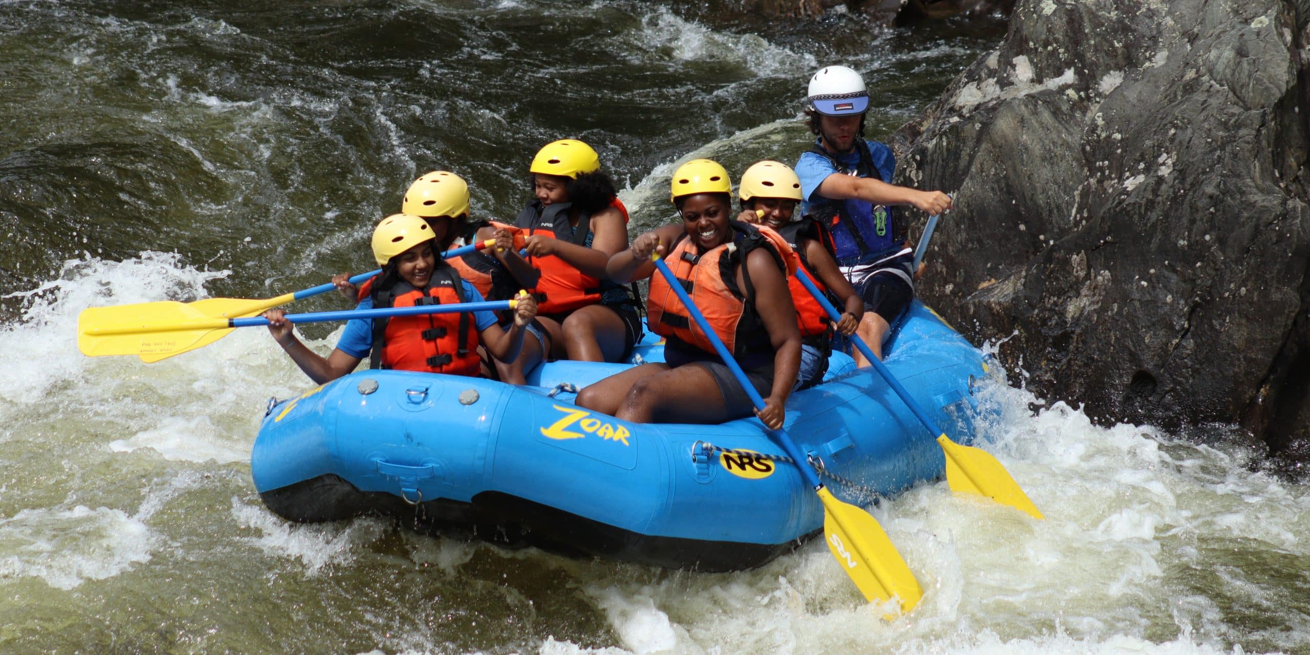 youth group getting splashed whitewater rafting