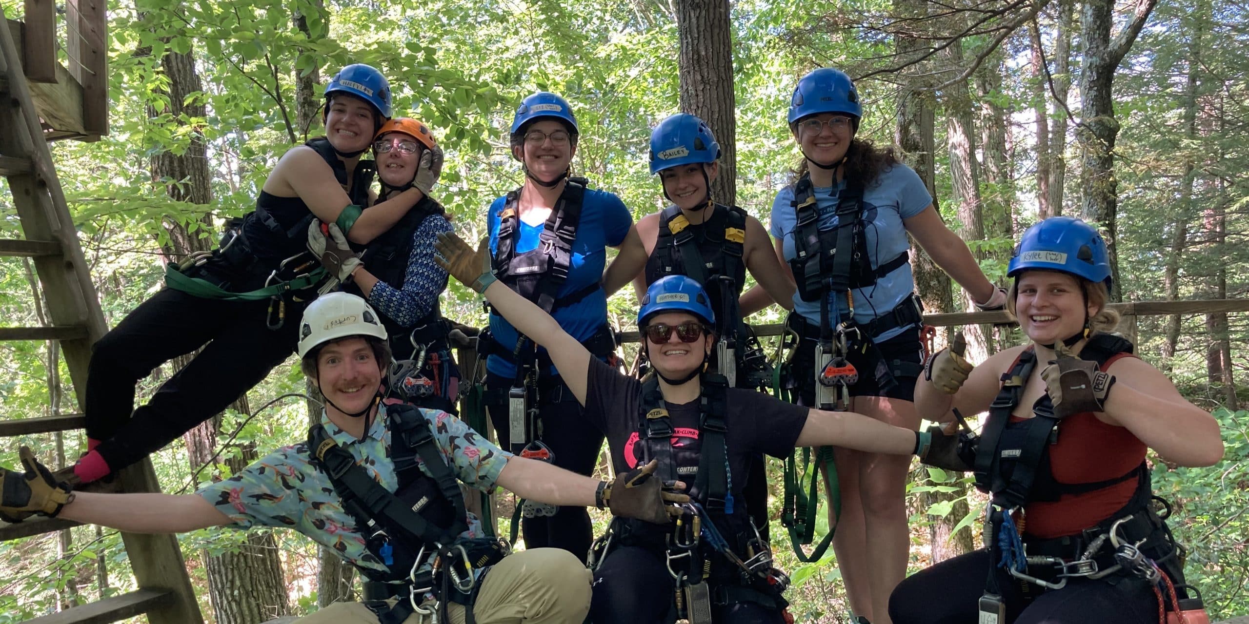 group of Zoar zip guides posing in zipline gear in the forest