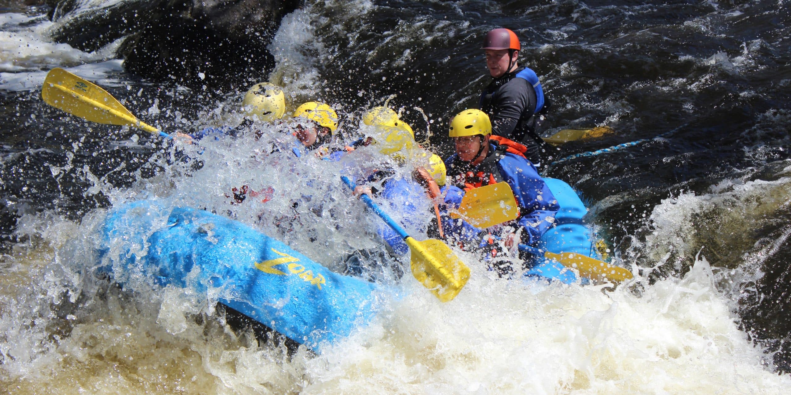 group getting splashed in rapids on the river